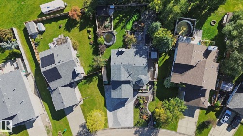 Expansive green space with mature trees, paved driveways, and multiple outbuildings - 38 Menalta Place, Cardiff, AB 