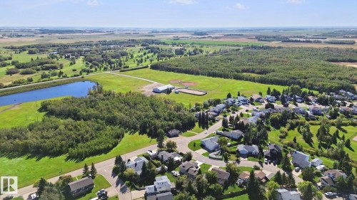Residential community with a pond, surrounding green spaces, and mature tree lines - 38 Menalta Place, Cardiff, AB 
