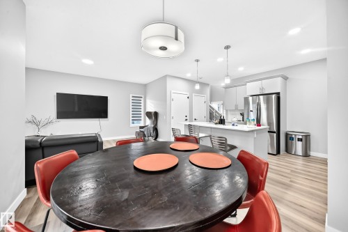 Open-concept layout featuring wood-finish flooring, recessed lighting, and a kitchen with stainless steel appliances - 2415 194 Street Nw, Edmonton, AB 