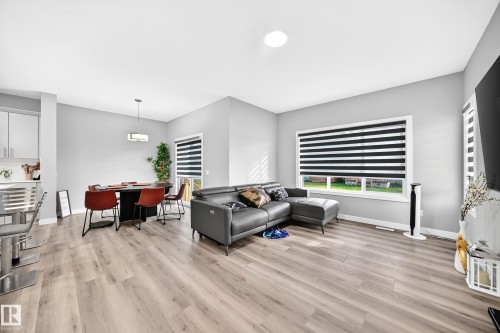 Recessed ceiling lighting, wood-finish flooring, white window trim, and a contemporary pendant light fixture - 2415 194 Street Nw, Edmonton, AB 