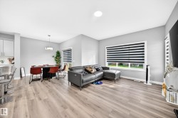 Recessed ceiling lighting, wood-finish flooring, white window trim, and a contemporary pendant light fixture - 