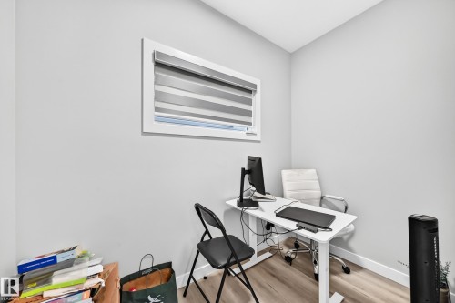 Recessed window with privacy blinds, light wood-finish flooring, and crisp white walls - 2415 194 Street Nw, Edmonton, AB 