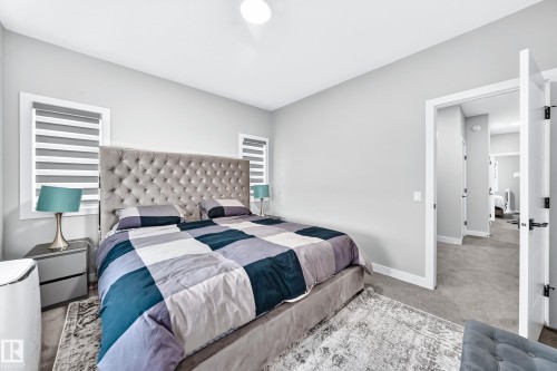 Expansive room with neutral carpeting, white trim, and a bright overhead light - 2415 194 Street Nw, Edmonton, AB 