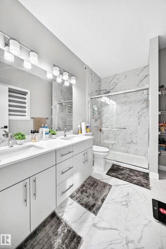 Dual vanity with undermount sinks, large wall-mounted mirror, and overhead track lighting - 2415 194 Street Nw, Edmonton, AB 