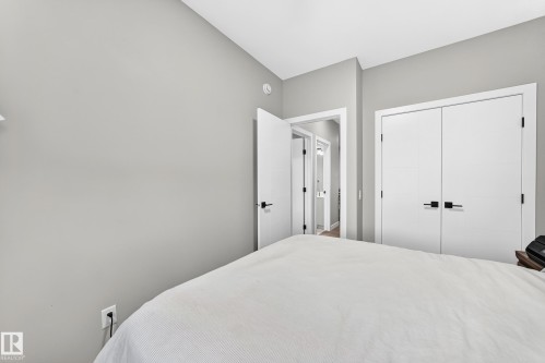 Light gray walls with white trim, a built-in closet with double doors, and black hardware - 2415 194 Street Nw, Edmonton, AB 