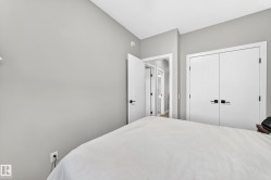 Light gray walls with white trim, a built-in closet with double doors, and black hardware - 