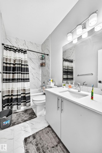 White vanity with stainless steel hardware, integrated sink, and full-width mirror - 2415 194 Street Nw, Edmonton, AB 