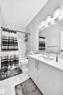 White vanity with stainless steel hardware, integrated sink, and full-width mirror - 
