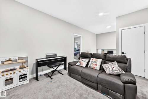 Recessed lighting illuminates neutral-toned walls and plush carpeting, enhancing the room's spacious feel - 2415 194 Street Nw, Edmonton, AB 