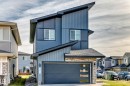 Contemporary exterior with angled roofline, vertical siding, stone accents, and an integrated garage with frosted glass panels - 2415 194 Street Nw, Edmonton, AB 