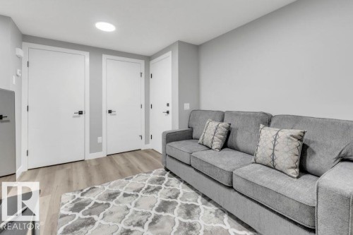 Recessed ceiling lighting, light gray wall finishes, wood-finish flooring, white doors with black hardware - 2415 194 Street Nw, Edmonton, AB 