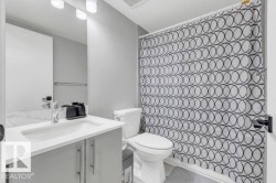 Vanity with integrated sink, chrome faucet, and gray cabinetry - 