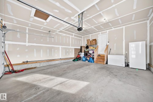 Concrete flooring, overhead garage door system, interior access door, wood-finish stairs - 2415 194 Street Nw, Edmonton, AB 