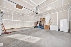 Concrete flooring, overhead garage door system, interior access door, wood-finish stairs - 