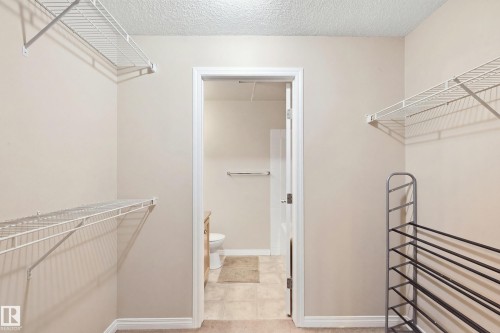 Walk-in closet with wire shelving and carpeting - #203 245 Edwards Dr Sw, Edmonton, AB 