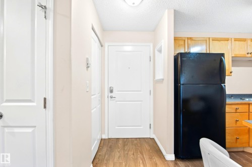 Wood-finish flooring throughout the entry and kitchen areas - #203 245 Edwards Dr Sw, Edmonton, AB 