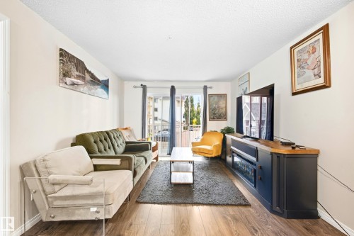 Wood-finish flooring throughout the main living area - #203 245 Edwards Dr Sw, Edmonton, AB 