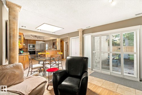 Kitchen featuring wood cabinetry, stainless steel appliances, and a breakfast bar - 13862 Ravine Drive Nw, Edmonton, AB 