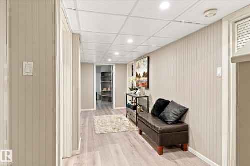 Wood-finish flooring with recessed lighting, beadboard wall paneling, and a drop-tile ceiling - 13862 Ravine Drive Nw, Edmonton, AB 