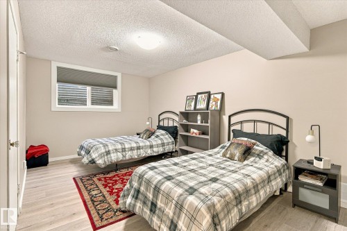 Soft neutral wall color, light-toned wood-finish flooring, white trim around window, recessed window with blinds, and ceiling-mounted light fixture - 13862 Ravine Drive Nw, Edmonton, AB 