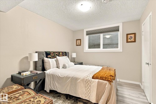 Window with horizontal blinds, light wood-finish flooring, and a flush-mount ceiling light - 13862 Ravine Drive Nw, Edmonton, AB 