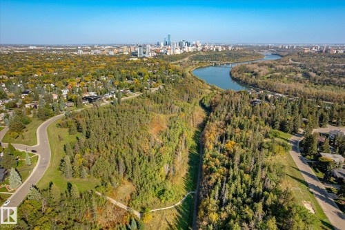Expansive treed landscape bordering a river with a distant city skyline - 13862 Ravine Drive Nw, Edmonton, AB 