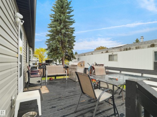 Expansive outdoor deck featuring dark wood-finish planking, a privacy railing, and direct exterior access - 52 Evergreen Park Northwest, Edmonton, AB 