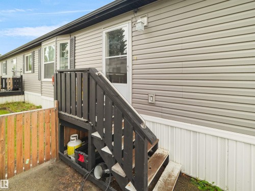 Siding exterior with white trim, featuring a dark-stained wood staircase with handrail - 52 Evergreen Park Northwest, Edmonton, AB 