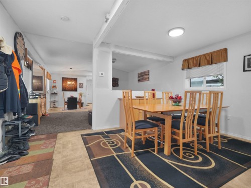 Open-concept interior featuring light-toned flooring, a built-in kitchen pass-through, and recessed lighting - 52 Evergreen Park Northwest, Edmonton, AB 