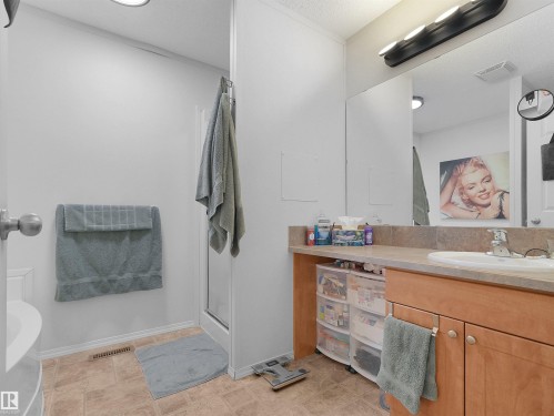 Vanity with integrated sink, wood-finish cabinetry, and stone-finish countertop - 52 Evergreen Park Northwest, Edmonton, AB 