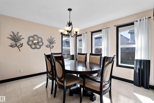 Recessed lighting, tiled flooring, multiple windows with dark trim, and a chandelier with glass shades - 11515 16 Avenue Sw, Edmonton, AB 