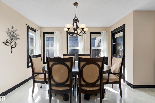 Recessed lighting, light-toned walls, and a multi-light chandelier illuminate the space - 11515 16 Avenue Sw, Edmonton, AB 