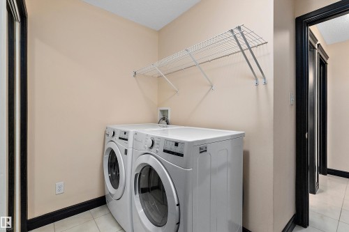 Laundry area featuring tile flooring and a wall-mounted wire shelf - 11515 16 Avenue Sw, Edmonton, AB 