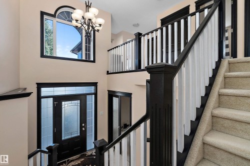 Two-story foyer with a decorative front entry door, transom window, and an arched window - 11515 16 Avenue Sw, Edmonton, AB 