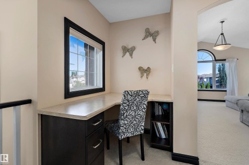 Built-in desk with a light-colored countertop and dark wood-finish cabinetry - 11515 16 Avenue Sw, Edmonton, AB 