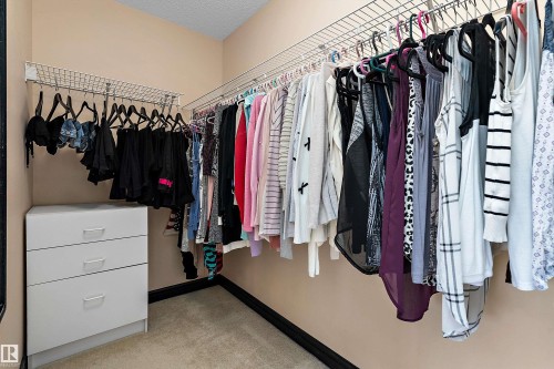 Walk-in closet featuring wire shelving, integrated hanging rods, and built-in drawers - 11515 16 Avenue Sw, Edmonton, AB 