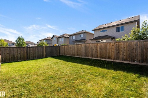 Enclosed backyard featuring a wood privacy fence and a manicured lawn - 11515 16 Avenue Sw, Edmonton, AB 