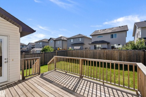 Expansive wooden deck with railing, leading to a landscaped lawn - 11515 16 Avenue Sw, Edmonton, AB 