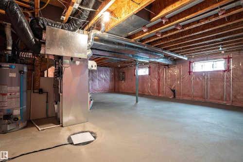 Unfinished basement featuring exposed wood joists, concrete flooring, and insulated walls - 11515 16 Avenue Sw, Edmonton, AB 