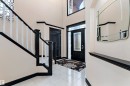 Two-story entry with tiled flooring, dark wood-finish trim, and a decorative front door with side lites - 11515 16 Avenue Sw, Edmonton, AB 