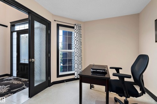 Entryway featuring a front door with decorative glass inserts, a single-pane window, and a frosted glass panel door - 11515 16 Avenue Sw, Edmonton, AB 