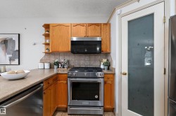 Kitchen featuring wood cabinetry, stainless steel range, built-in microwave, durable countertops, and a full-light door with frosted glass - 