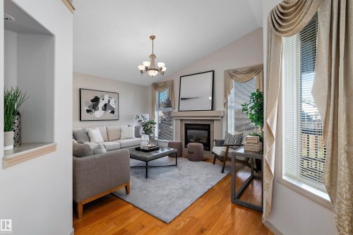 Vaulted ceilings, hardwood flooring, fireplace, recessed wall niche, and chandelier - 1046 Blackburn Close Sw, Edmonton, AB 