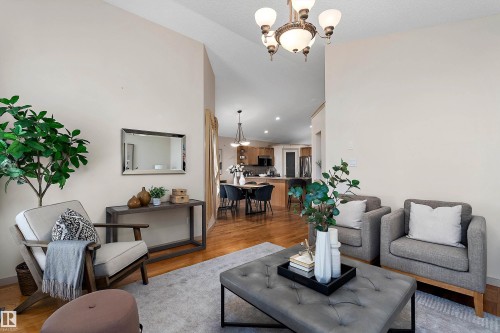 Vaulted ceilings, wood-finish flooring, and a decorative chandelier create an inviting space - 1046 Blackburn Close Sw, Edmonton, AB 