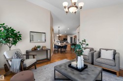 Vaulted ceilings, wood-finish flooring, and a decorative chandelier create an inviting space - 