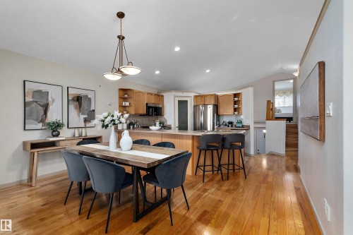 Open-concept living space with wood-finish flooring, a vaulted ceiling, and recessed lighting - 1046 Blackburn Close Sw, Edmonton, AB 