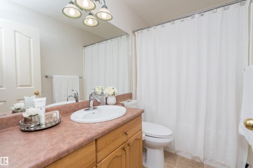 Vanity with wood-finish cabinetry, integrated sink, and an expansive countertop - 1046 Blackburn Close Sw, Edmonton, AB 