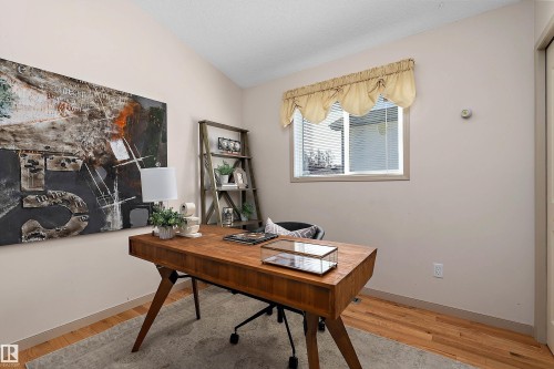 Vaulted ceiling, hardwood flooring, single window with blinds, light-toned wall paint, and a built-in closet with a closed door - 1046 Blackburn Close Sw, Edmonton, AB 
