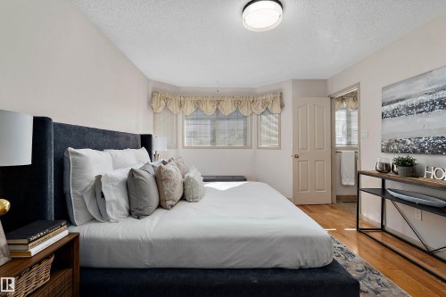 Wood-finish flooring, white paneled door, and a multi-pane window with valance - 1046 Blackburn Close Sw, Edmonton, AB 