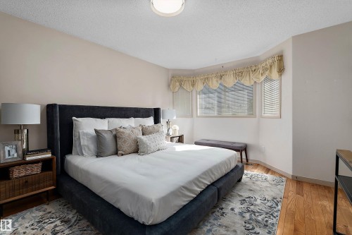 Bay window with blinds, wood-finish flooring, and overhead lighting - 1046 Blackburn Close Sw, Edmonton, AB 